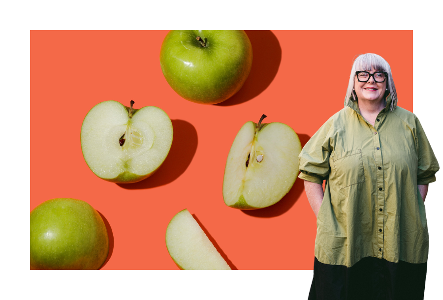 Pictured, Head of the Canny Plan Management team Anthea Taylor ,standing in front of an orange background with green cut open apples.